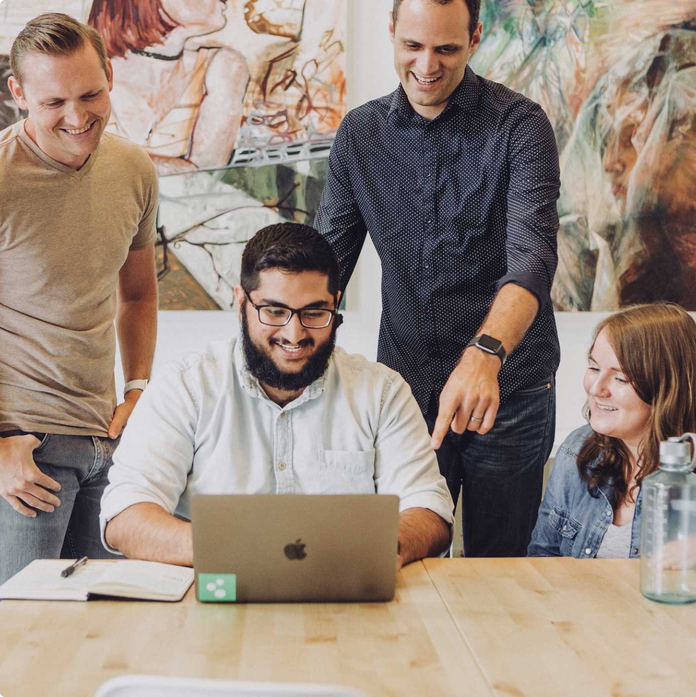 A studio team reviewing work together on a laptop