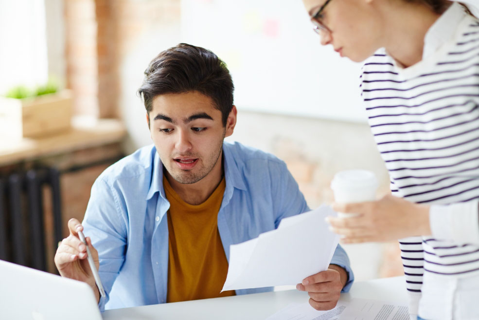 Two colleagues reviewing a financial document together